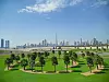 Dubai skyline med Burj Khalifa bak et grønt parkområde med palmer