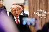Donald Trump passerer foran World Economic Forum-logo under møte i Davos.