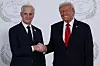 Donald Trump og Jonas Gahr Støre står side om side og håndhilser foran en hvit bakvegg.