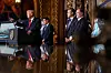 Trump taler ved et podie med rådgivere ved siden av i en gyllent dekorert sal på Mar-a-Lago.