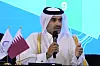 Saad Sherida al-Kaabi taler i mikrofon ved et podium med Qatar-flagg under pressekonferanse.