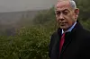 Benjamin Netanyahu står utendørs ved Yad Vashem i tåke