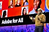 Shantanu Narayen på scenen foran stor skjerm med teksten 'Adobe for All' under Adobe Summit.