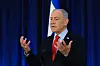 Benjamin Netanyahu taler under pressekonferanse med israelsk flagg bak seg