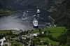 Utsikt over Geiranger med flere cruiseskip i fjorden og Hotel Union i forgrunnen.