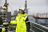 Sylvi Listhaug i gult vernetøy på Johan Sverdrup-plattformen med hav og installasjoner bak