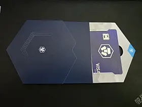Krypto.com Visa-kort i mørkeblå eske på sort bordflate