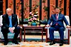 Xi Jinping og Donald Trump sitter i lenestoler med et blomsterarrangement og bord mellom seg i Zhongnanhai-hagen.