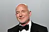 Jeff Bezos i sort smoking foran grå bakgrunn på Vanity Fair Oscar Party i Los Angeles.