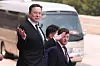 Elon Musk går foran en svart bil utenfor Folkets store hall i Beijing under en velkomstseremoni.