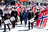 Buekorps marsjerer foran barnetoget i Bergen med norske flagg under 17. mai-feiringen.