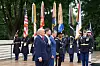 Trump, Vance og Hegseth står i en seremoni foran flagg og militærpersonell ved Arlington National Cemetery.