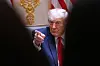 Donald Trump peker under et kabinettmøte i Det hvite hus, med amerikansk flagg og gullornamenter i bakgrunnen.
