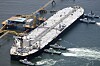 Råoljetankeren Idemitsu Maru seiler ved en kai utenfor Chita, med taubåter rundt skipet.