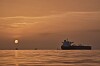 Soloppgang over et ankret tankskip i et rolig hav utenfor Qeshm Island, Iran.