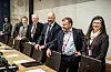 Fem personer står ved et møtebord i et konferanserom med redskap og navneskilt før møte i Oslo.