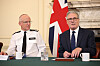 Mark Rowley og Keir Starmer sitter ved et bord under et møte med britisk flagg i bakgrunnen.