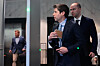 Sam Altman og Greg Brockman ankommer U.S. District Court i Oakland, med sikkerhetsvakt i en korridor.