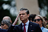 Pete Hegseth salutterer under en seremoni på en kirkegård i Normandie.