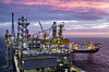 Opplyst Johan Sverdrup feltsenter i Nordsjøen ved solnedgang.