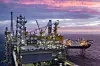 Opplyst Johan Sverdrup feltsenter i Nordsjøen ved solnedgang.