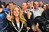 Gwynne Shotwell poserer smilende med seiersgest ved Nasdaq MarketSite under SpaceX-børsnoteringen.