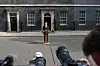 Keir Starmer taler ved podium utenfor 10 Downing Street mens fotografer står i forgrunnen.
