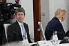 Sam Altman og Donald Trump sitter ved et møtebord under G7-toppmøtet, med kameraer og vannflasker i bakgrunnen.