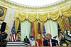 President Donald Trump taler i Det ovale kontor, med amerikanske flagg og presidentsegl i bakgrunnen.