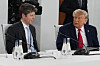 Donald Trump og Sam Altman sitter ved et møtebord og snakker under G7-toppmøtet.