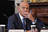 Claudio Descalzi sits at a White House meeting table, listening with his hand near his face.