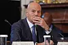 Claudio Descalzi sits at a White House meeting table, listening with his hand near his face.