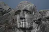 Nærbilde av George Washington-ansiktet på Mount Rushmore med regnstriper over steinen.