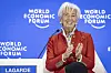 Christine Lagarde speaks onstage at the World Economic Forum in Davos, with a blue WEF backdrop.