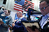 Børsmeglere bruker håndholdte enheter og skjermer på handelsgulvet i New York Stock Exchange.