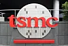 TSMC-logo i rødt foran en rund, lys fasade ved hovedkvarteret i Hsinchu, Taiwan.