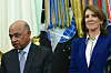 Arvind Krishna og Ruth Porat står i Det ovale kontor mens Donald Trump taler ved en signering.