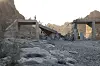 Delvis ødelagt bru med sammenraste seksjoner og mennesker som står i ruinområdet i sørlige Iran.
