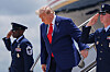 Donald Trump går ned trappen fra Air Force One ved Dobbins Air Reserve Base med to uniformerte tjenestepersoner ved siden av.