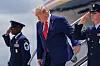 Donald Trump går ned trappen fra Air Force One ved Dobbins Air Reserve Base med to uniformerte tjenestepersoner ved siden av.