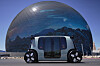 En førerløs Amazon Zoox-taxi står foran The Sphere på Las Vegas Strip.