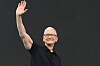 Tim Cook vinkar med armen hevet foran en mørk bakgrunn under Apples WWDC.