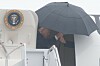 President Donald Trump går av Air Force One under en stor svart paraply ved Joint Base Andrews.