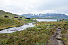 Ramsjøhytta ved Ramsjøen i Tydalen med sti, myr og snødekte fjell i bakgrunnen.
