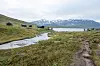 Ramsjøhytta ved Ramsjøen i Tydalen med sti, myr og snødekte fjell i bakgrunnen.