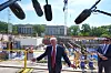 Donald Trump står på en byggeplass ved Det hvite hus, omgitt av mikrofoner, stillaser og anleggsutstyr.