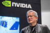 Jensen Huang står foran Nvidia-logoen og en skjerm under et arrangement i Sherman, Texas.