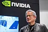 Jensen Huang står foran Nvidia-logoen og en skjerm under et arrangement i Sherman, Texas.