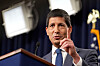 Kevin Warsh taler ved en talerstol og løfter én finger under en pressekonferanse.