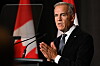 Mark Carney taler ved en talerstol foran Canadas flagg i Toronto.